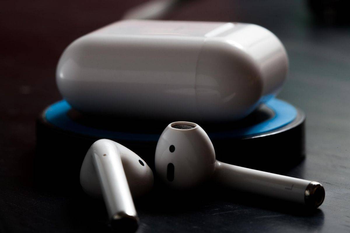 A set of AirPods with its charging case
