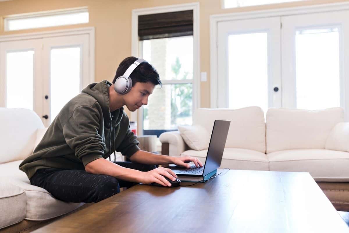 Young man using a laptop with Bluetooth headphones
