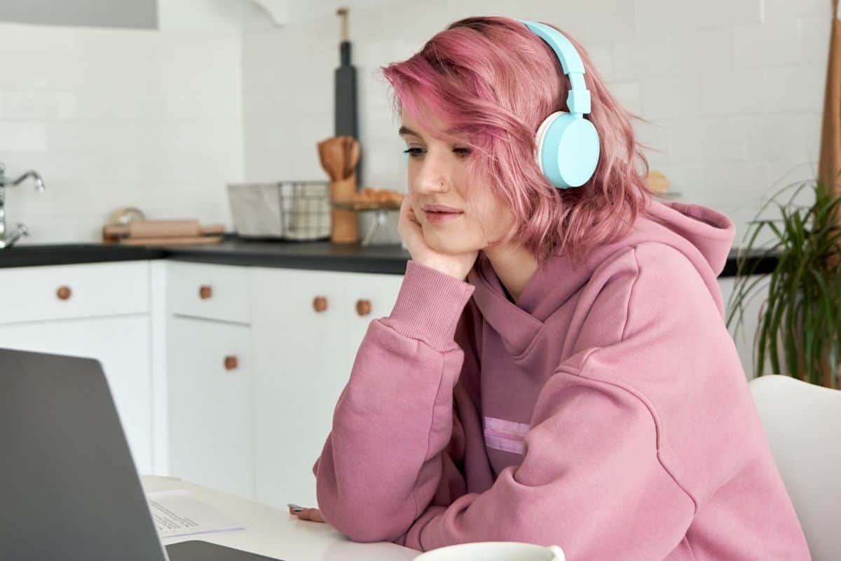 Girl sitting with facetime on laptop while wearing headphones
