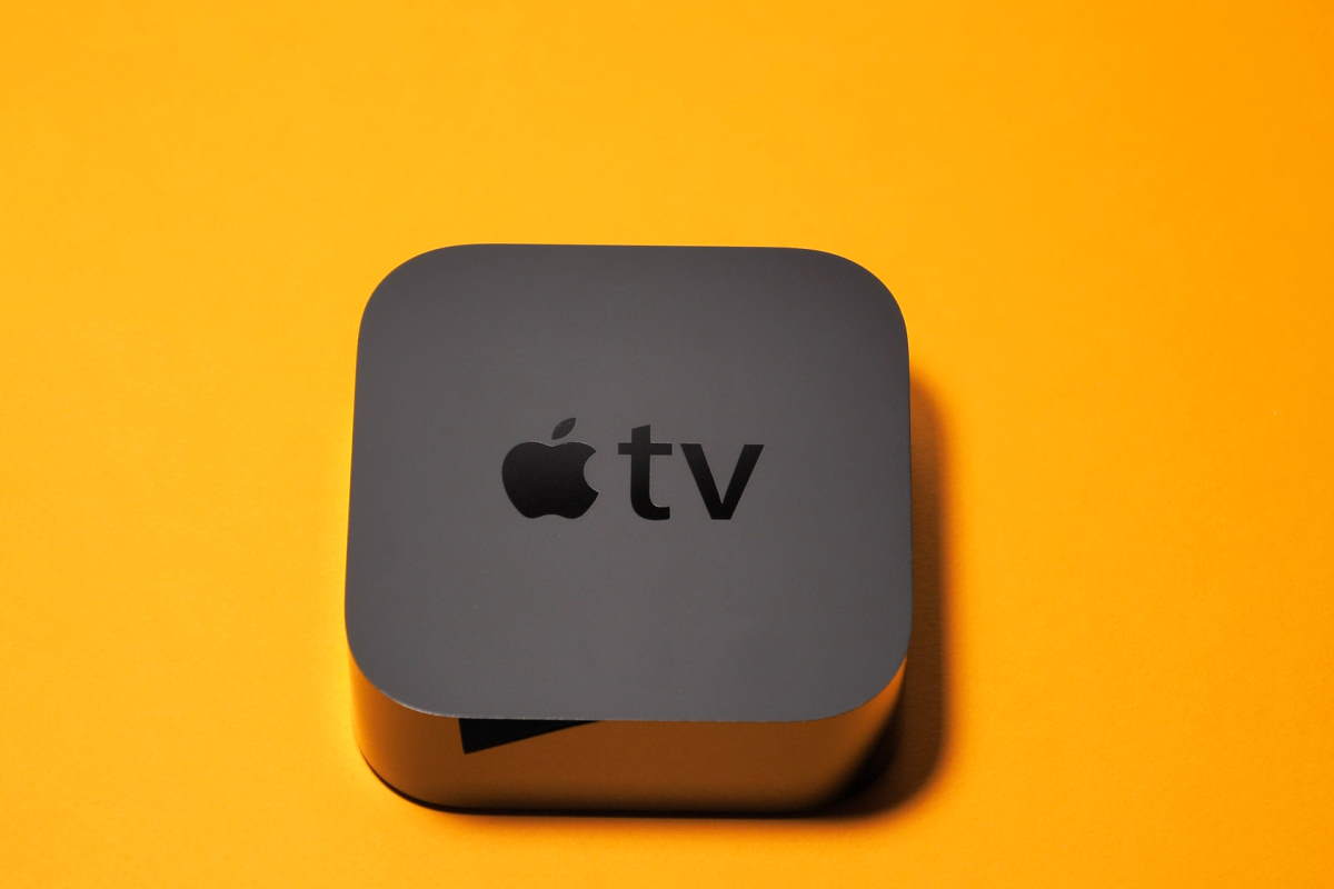 Apple TV device on orange background